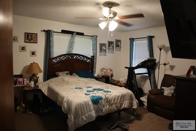 carpeted bedroom with a textured ceiling and ceiling fan