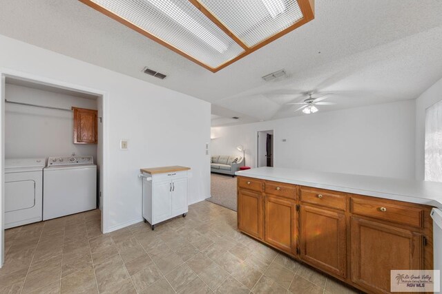 kitchen featuring ceiling fan, dishwasher, a textured ceiling, and independent washer and dryer