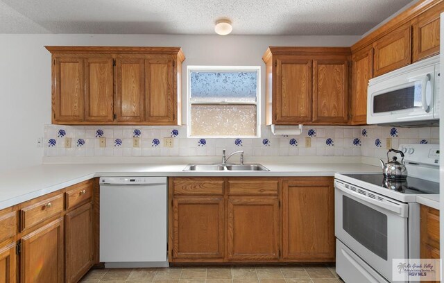 kitchen with backsplash, sink, and white appliances