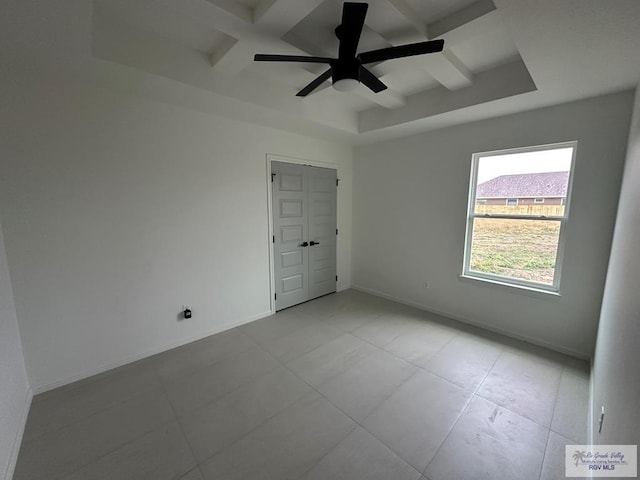 empty room featuring beam ceiling, ceiling fan, and coffered ceiling