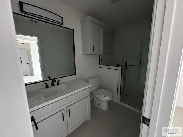 bathroom with vanity, toilet, and a shower with door