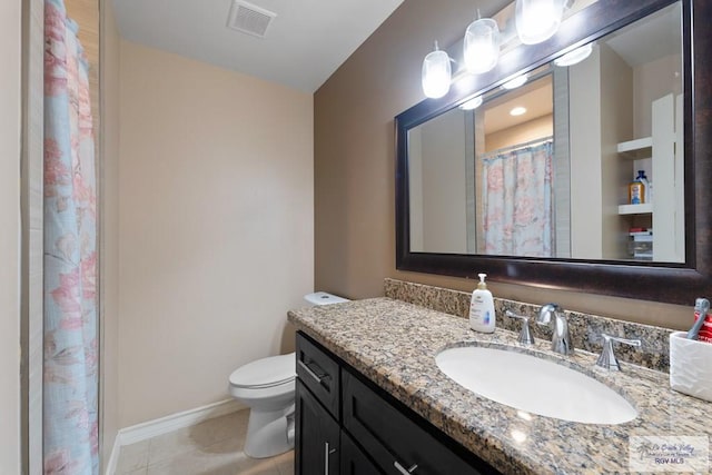 bathroom featuring vanity, tile patterned floors, and toilet