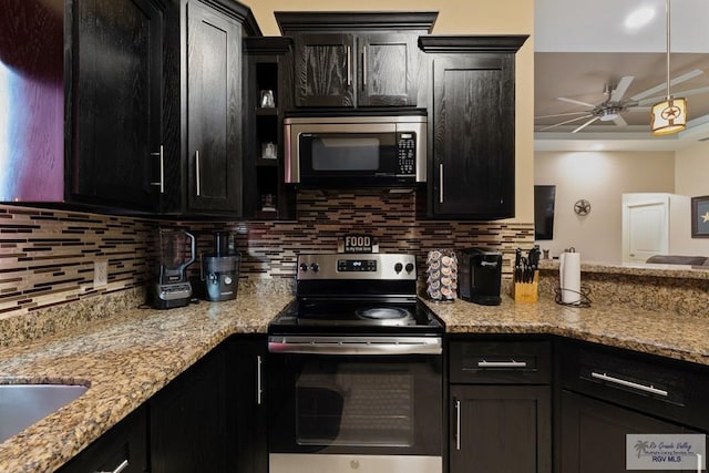 kitchen featuring light stone counters, hanging light fixtures, appliances with stainless steel finishes, ceiling fan, and backsplash