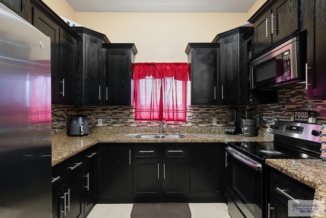 kitchen featuring light tile patterned flooring, sink, tasteful backsplash, light stone counters, and stainless steel appliances