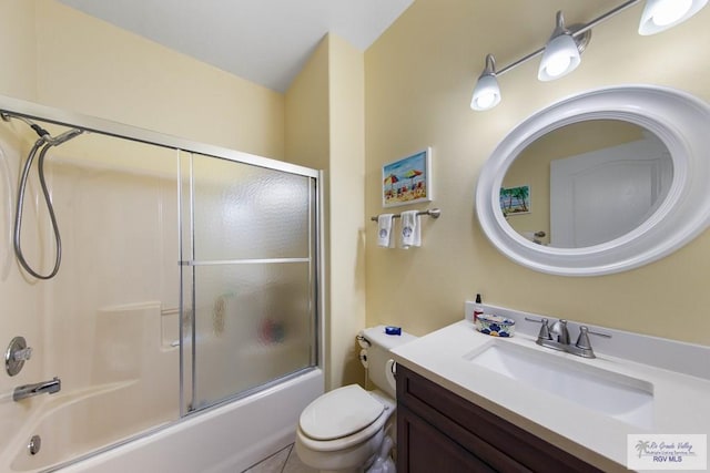 bathroom featuring enclosed tub / shower combo, vanity, and toilet