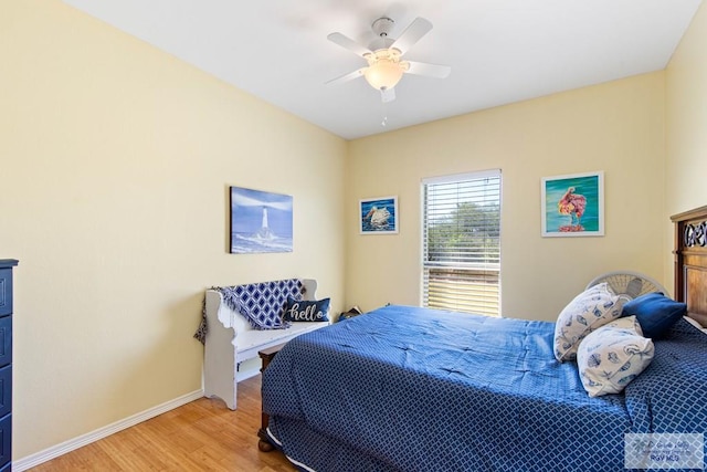 bedroom featuring ceiling fan, light wood-style flooring, and baseboards