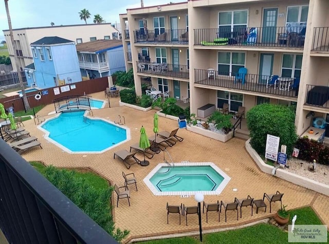 pool with a patio and fence