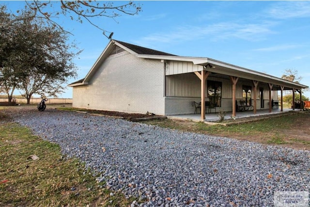 view of property exterior featuring a patio and brick siding