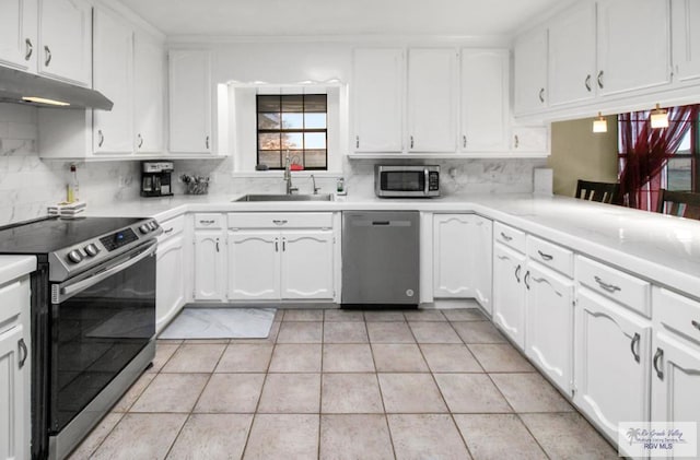 kitchen featuring tasteful backsplash, appliances with stainless steel finishes, white cabinetry, and a sink