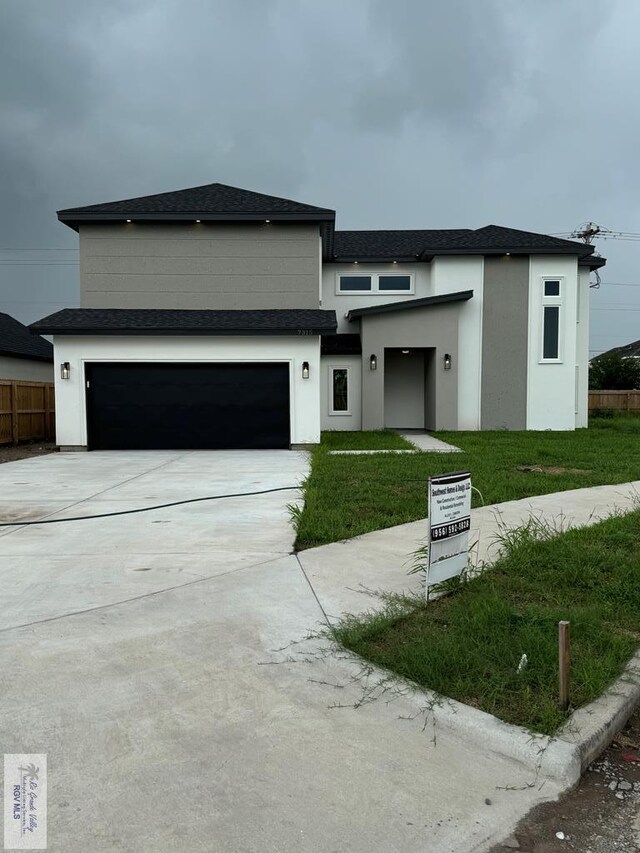 view of front of property with a garage and a front lawn