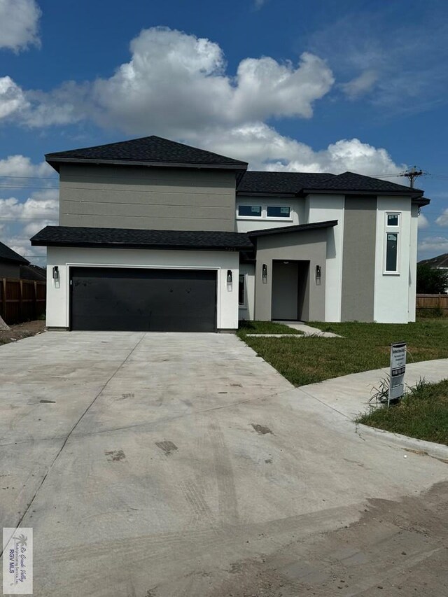 view of front of home with a garage and a front lawn