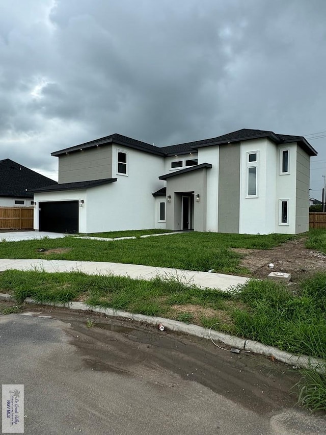 view of front of house with a garage and a front lawn