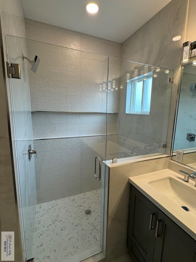 bathroom with vanity and a shower with shower door