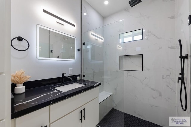 bathroom featuring vanity and a tile shower