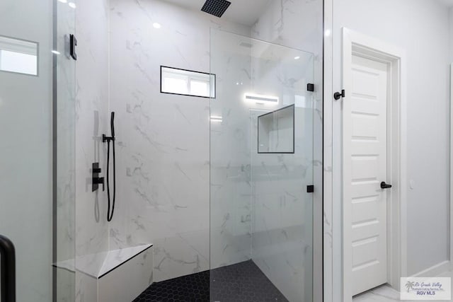 bathroom with a shower with door