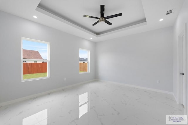 unfurnished room with a raised ceiling and ceiling fan