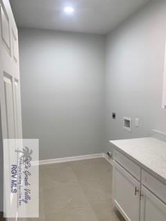 washroom with hookup for an electric dryer, cabinets, and washer hookup