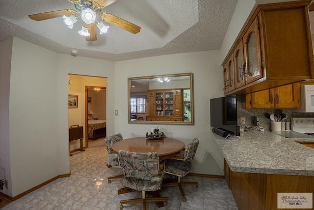 dining room featuring ceiling fan and a textured ceiling