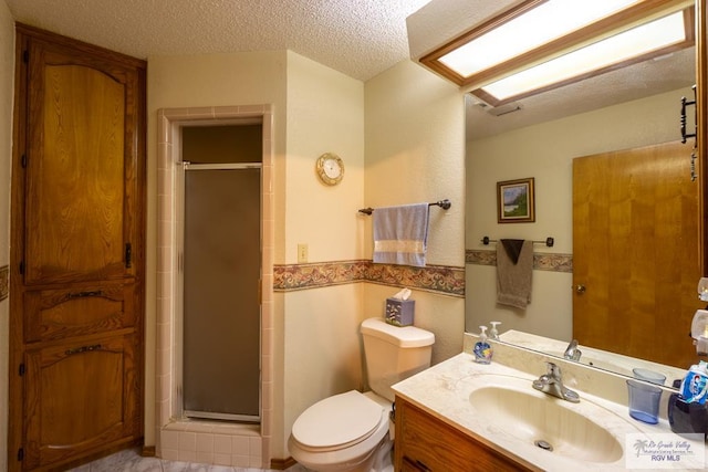 bathroom with a textured ceiling, toilet, walk in shower, and vanity