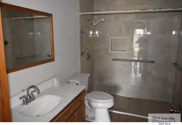 bathroom featuring toilet and a tile shower