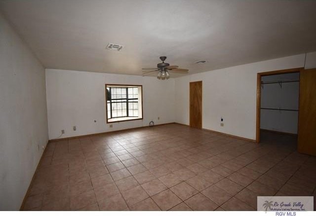 unfurnished room featuring light tile patterned floors, baseboards, ceiling fan, and visible vents
