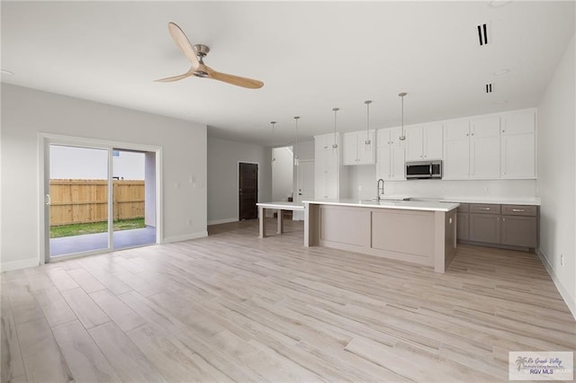 2507 E Solar Dr Lot 45, Mission, TX 78501 - kitchen featuring white cabinetry, ceiling fan, light hardwood / wood-style flooring, pendant lighting, and a kitchen island with sink