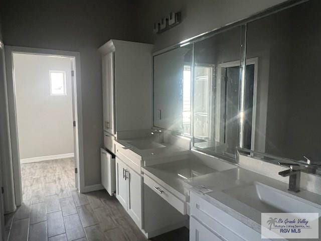 9206 Empress Ln, Harlingen, TX 78552 - bathroom featuring a sink, wood finished floors, and baseboards
