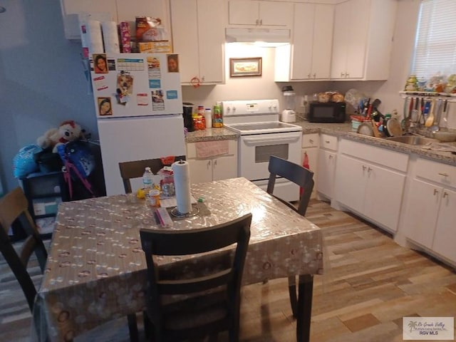 kitchen featuring light stone countertops, white appliances, sink, white cabinets, and light hardwood / wood-style floors