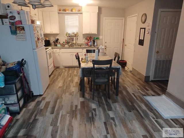 kitchen with white cabinetry, white appliances, and dark hardwood / wood-style floors