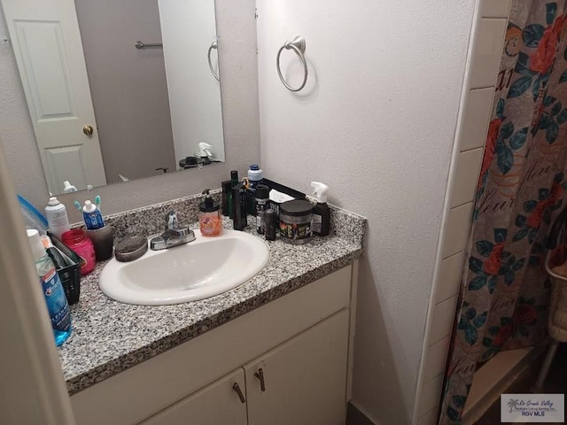 bathroom with a shower with shower curtain and vanity