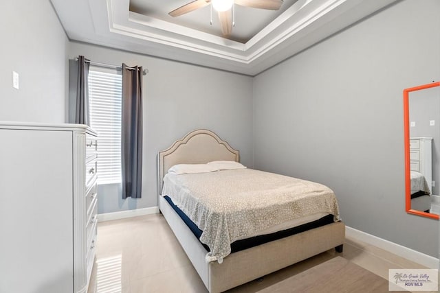 bedroom with a tray ceiling and ceiling fan