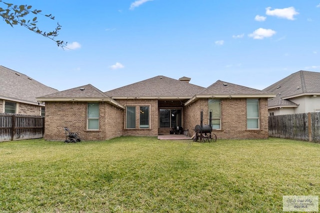 rear view of house featuring a yard and a patio