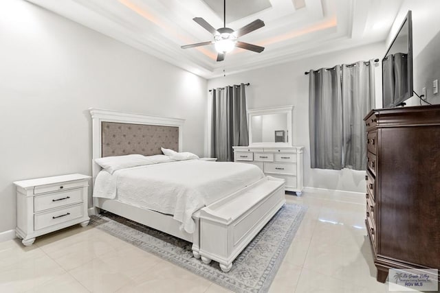 tiled bedroom with ceiling fan and a raised ceiling