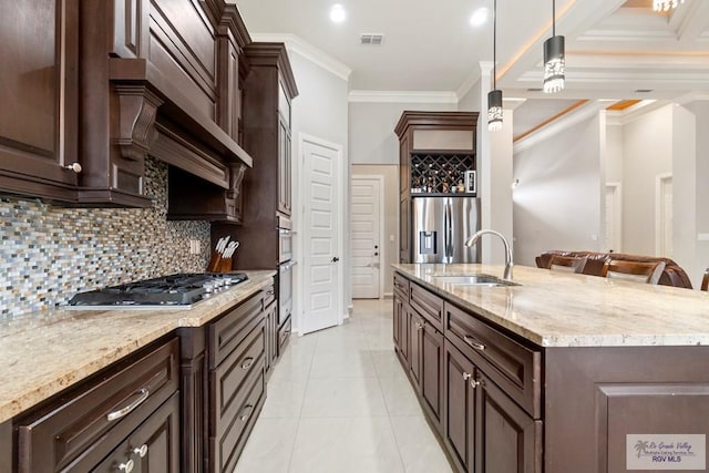 kitchen featuring pendant lighting, a breakfast bar, sink, crown molding, and stainless steel appliances