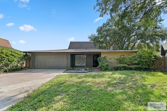 single story home with a garage and a front lawn