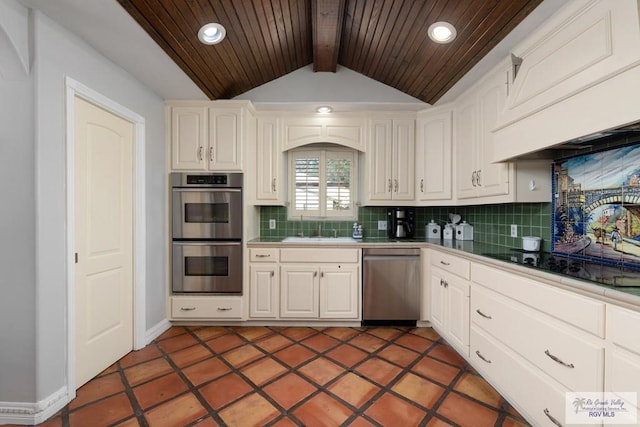 kitchen with decorative backsplash, appliances with stainless steel finishes, vaulted ceiling with beams, and white cabinetry