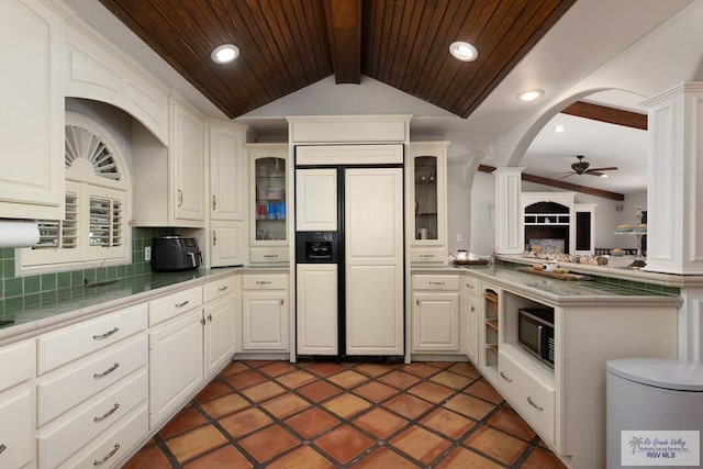 kitchen with white cabinets, lofted ceiling with beams, ceiling fan, tasteful backsplash, and paneled fridge