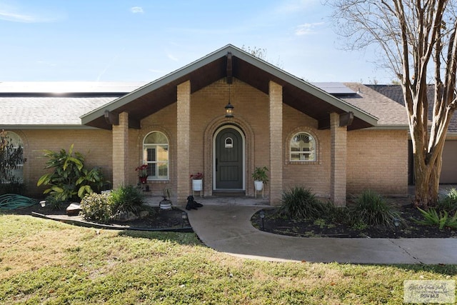 view of front of house featuring covered porch, solar panels, and a front lawn