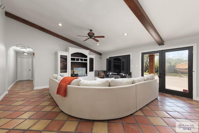 tiled living room featuring ceiling fan, french doors, and lofted ceiling with beams