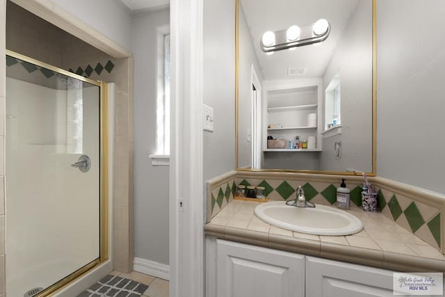 bathroom with decorative backsplash, vanity, plenty of natural light, and an enclosed shower