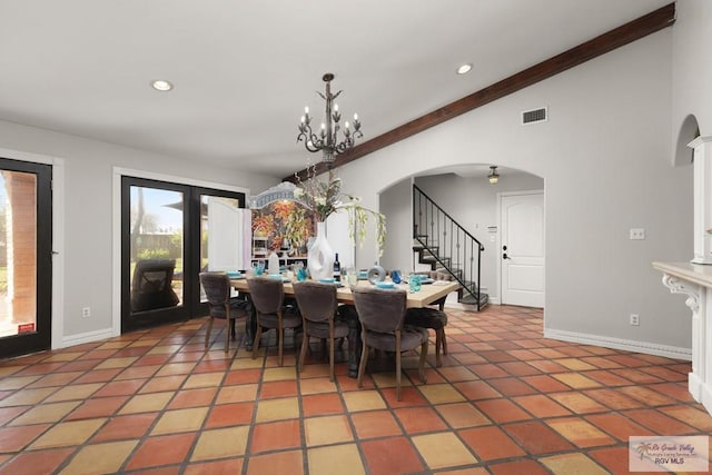 tiled dining area featuring a chandelier and vaulted ceiling