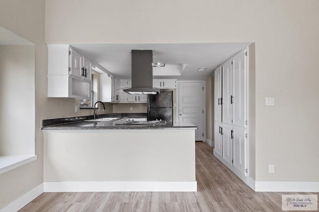 45 Varadero St, Brownsville, TX 78526 - kitchen featuring freestanding refrigerator, dark countertops, island range hood, a sink, and a peninsula