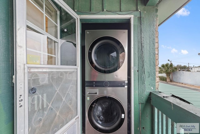 clothes washing area with stacked washer and dryer and laundry area