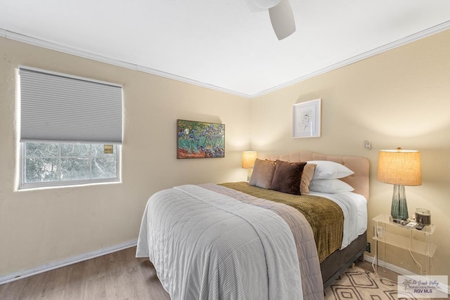 bedroom with ornamental molding, wood finished floors, a ceiling fan, and baseboards