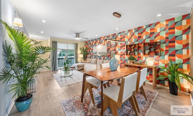 dining space featuring an accent wall, recessed lighting, wood finished floors, and wallpapered walls