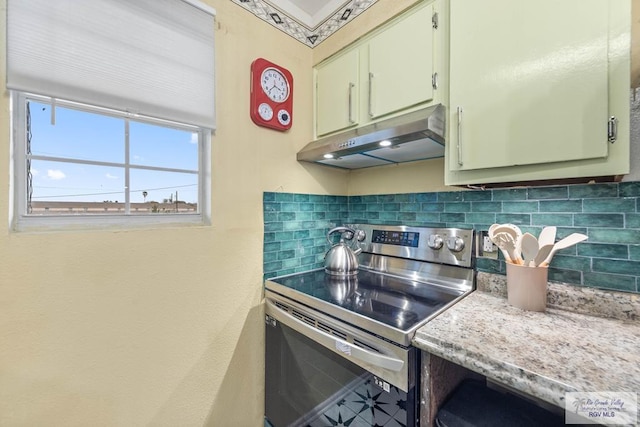 kitchen with decorative backsplash, light countertops, under cabinet range hood, and stainless steel electric range