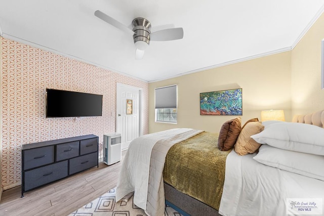 bedroom featuring ceiling fan, wallpapered walls, light wood-type flooring, and crown molding