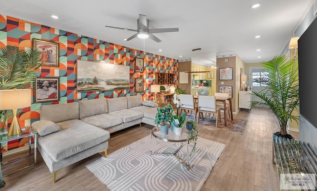 living area with recessed lighting, an accent wall, wood finished floors, baseboards, and wallpapered walls