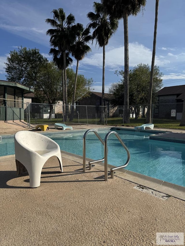 pool with a patio and fence