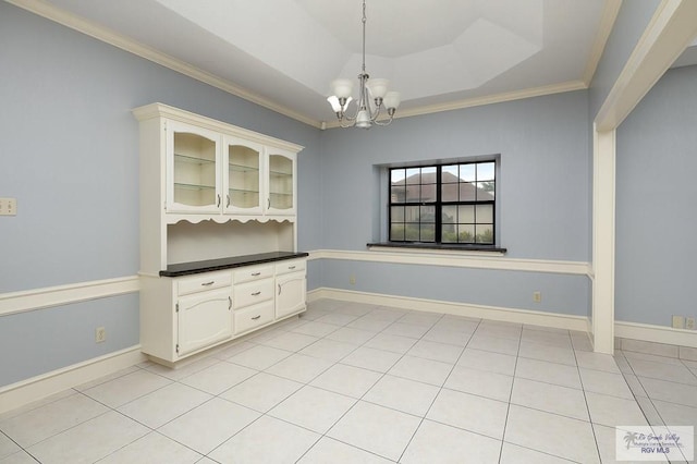 3100 Umar Ave, Mcallen, TX 78504 - unfurnished dining area featuring ornamental molding, a chandelier, a tray ceiling, light tile patterned flooring, and baseboards